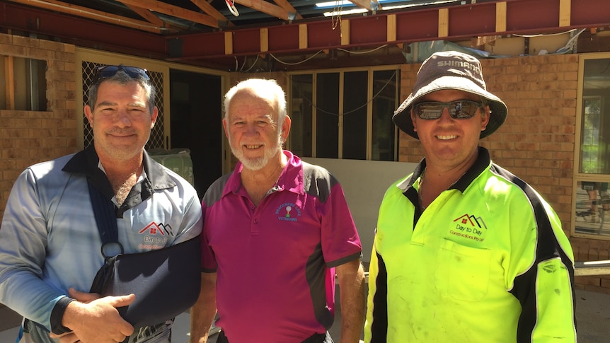 Three men outside a house renovation project.