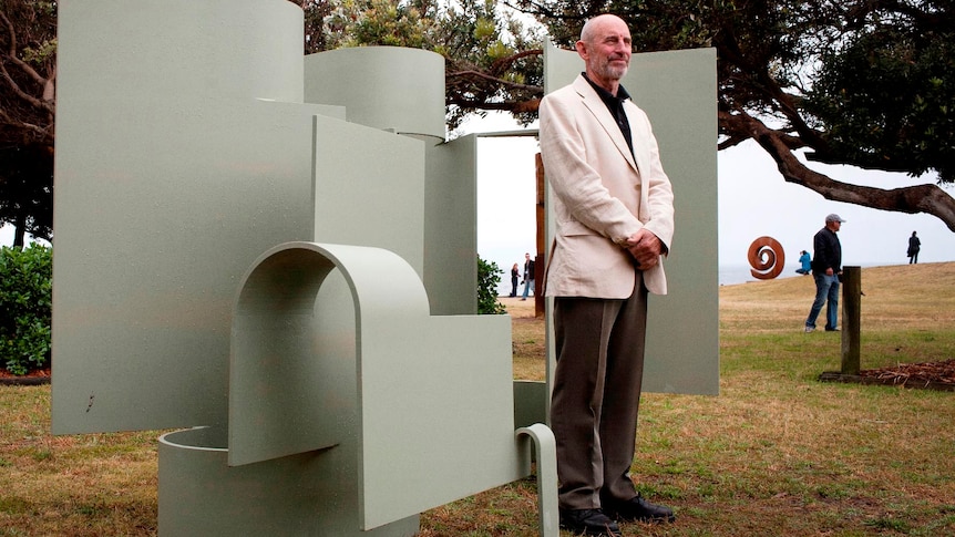 Artist stands with his winning sculpture at the Sculpture by the Sea exhibition in Sydney.