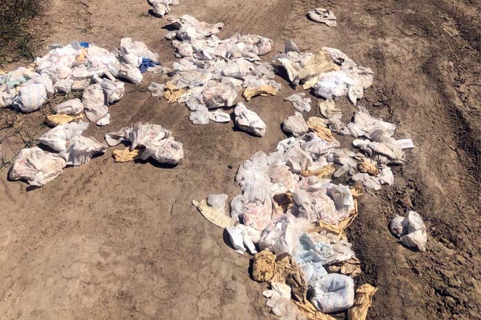 A pile of discarded baby nappies on a dirt road