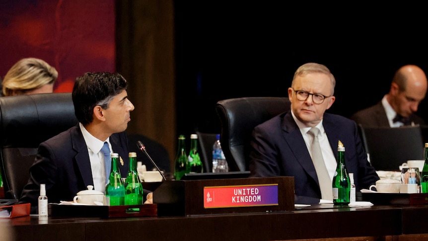 Anthony Albanese and Rishi Sunak sit at a table 