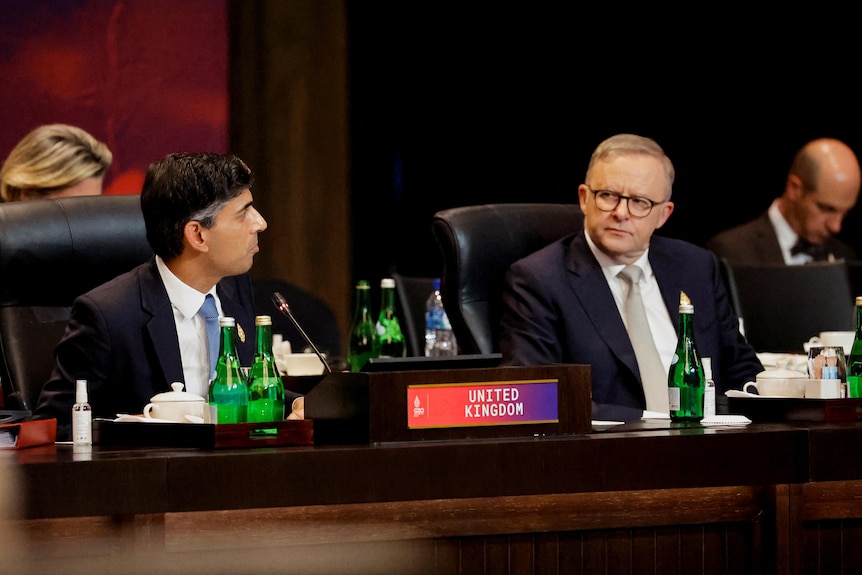 Anthony Albanese and Rishi Sunak sit at a table 