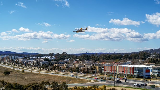 A delivery drones flies above buildings