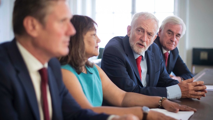 Jeremy Corbyn sits at a table with other MPs.