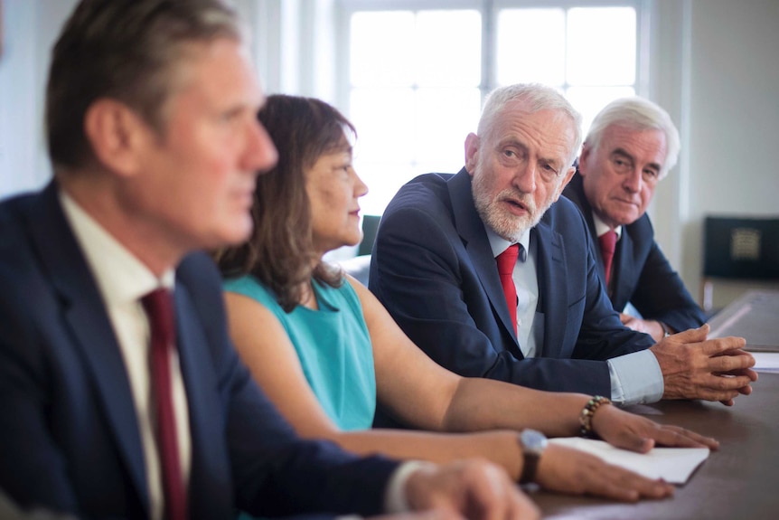 Jeremy Corbyn sits at a table with other MPs.