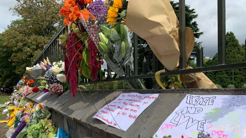 Flowers and messages left at a memorial in the Christchurch Botanic Gardens.