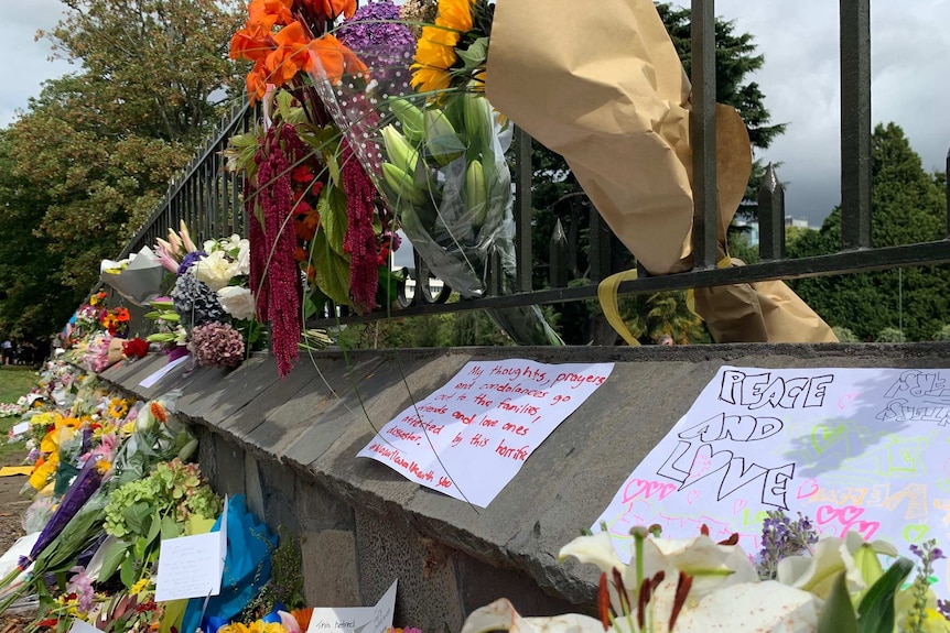 Flowers and messages left at a memorial in the Christchurch Botanic Gardens.