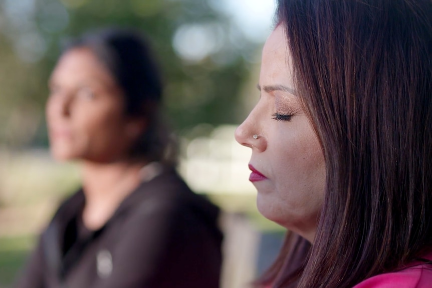 A woman closes her eyes in meditation.