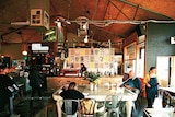 Customers sip coffee while waitstaff work at a Melbourne cafe