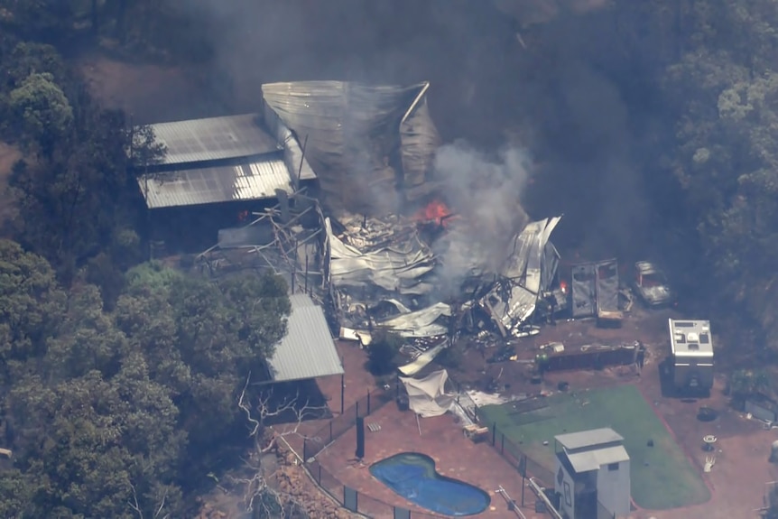 An aerial image ofthe rubble of a house that caught fire and collapsed in a semi-rural area during a bushfire.