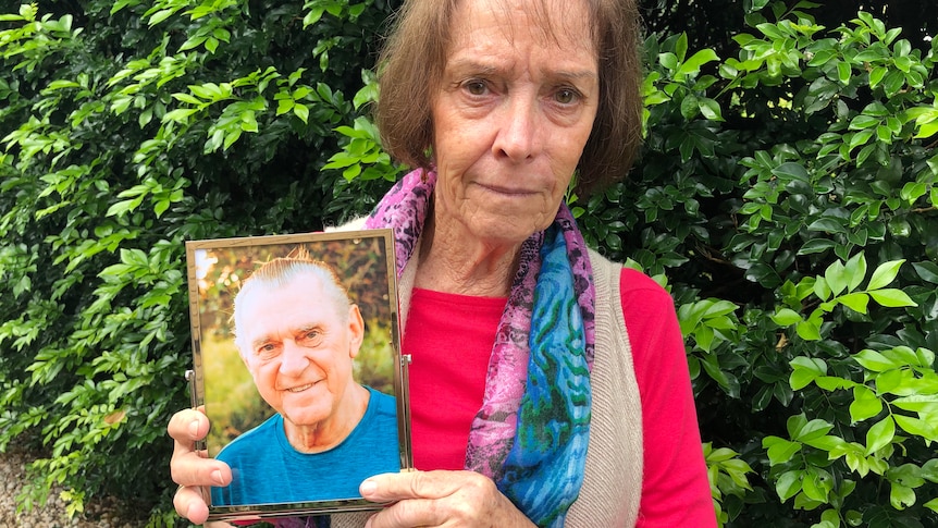 Lea King holds a photo of her husband Colin