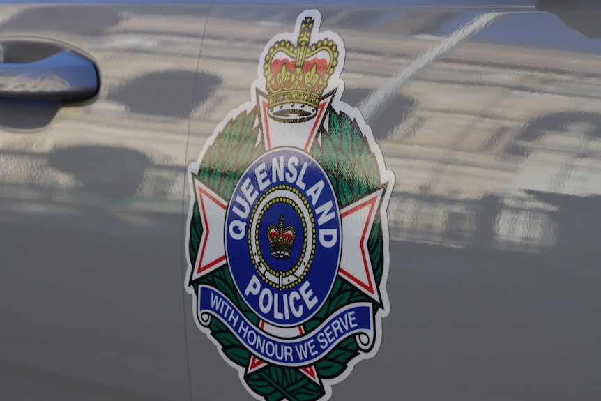 Close-up of the Queensland police logo on the side of the police car