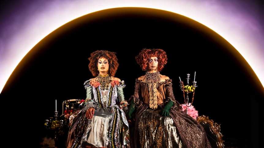 Cerulean and Stone Motherless Cold are sitting in front of an eclipse wearing period costumes.