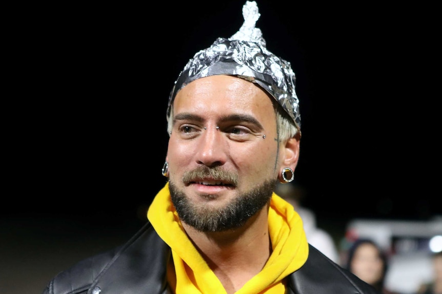 A man wearing a hat made of tin foil.