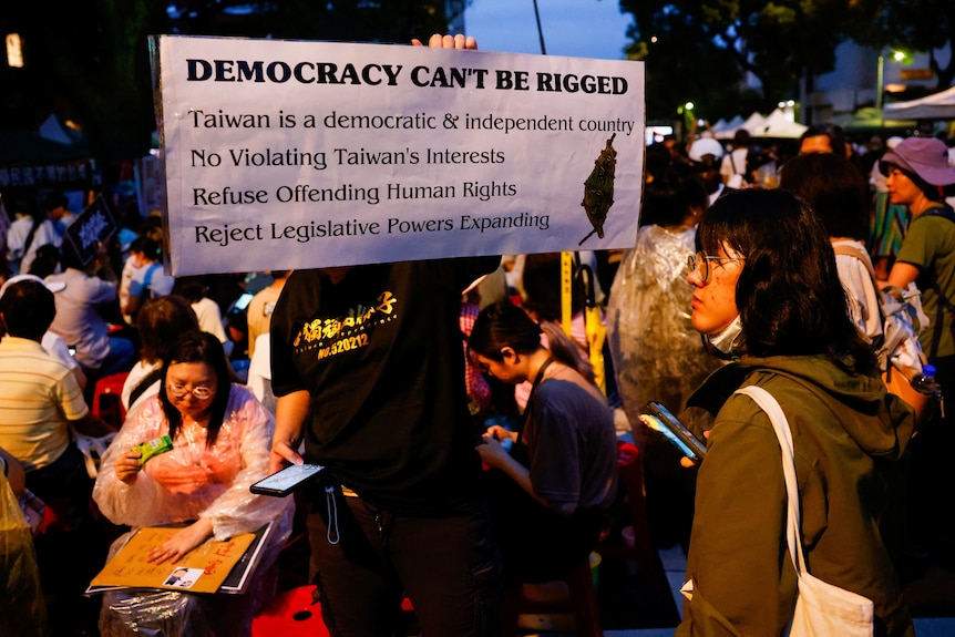a sign reads: "Democracy Can't Be Rigged"