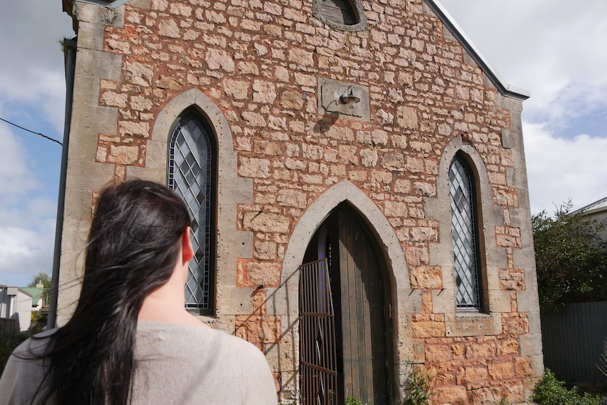 Woman looking at an old vacant church building