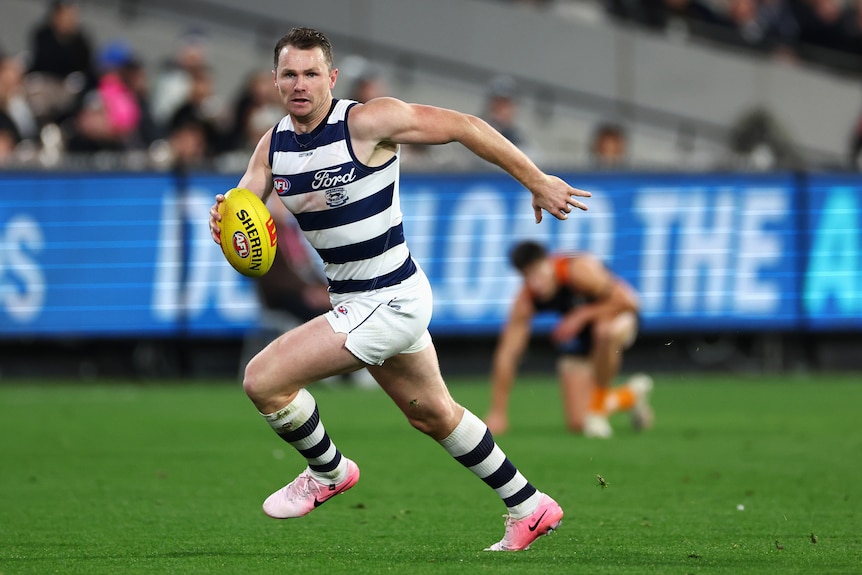 Patrick Dangerfield runs with the football in hand