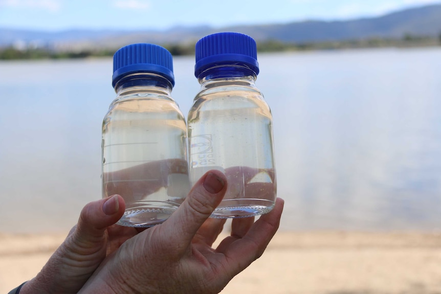 Two bottles of water containing water from Lake Tuggeranong and a sample from Lake Burley Griffin.