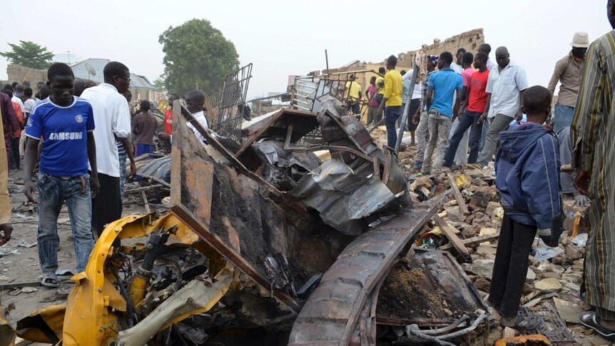 People look at damage in a market area after a bomb explosion in Ajilari-Gomari, near the airport in Maiduguri, Nigeria.