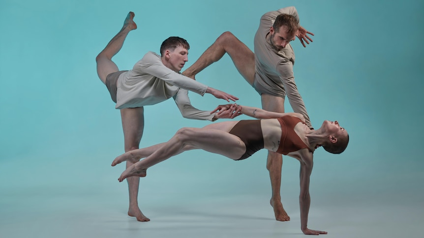 Three dancers contort their bodies to form a strange and connected shape against a green backdrop.