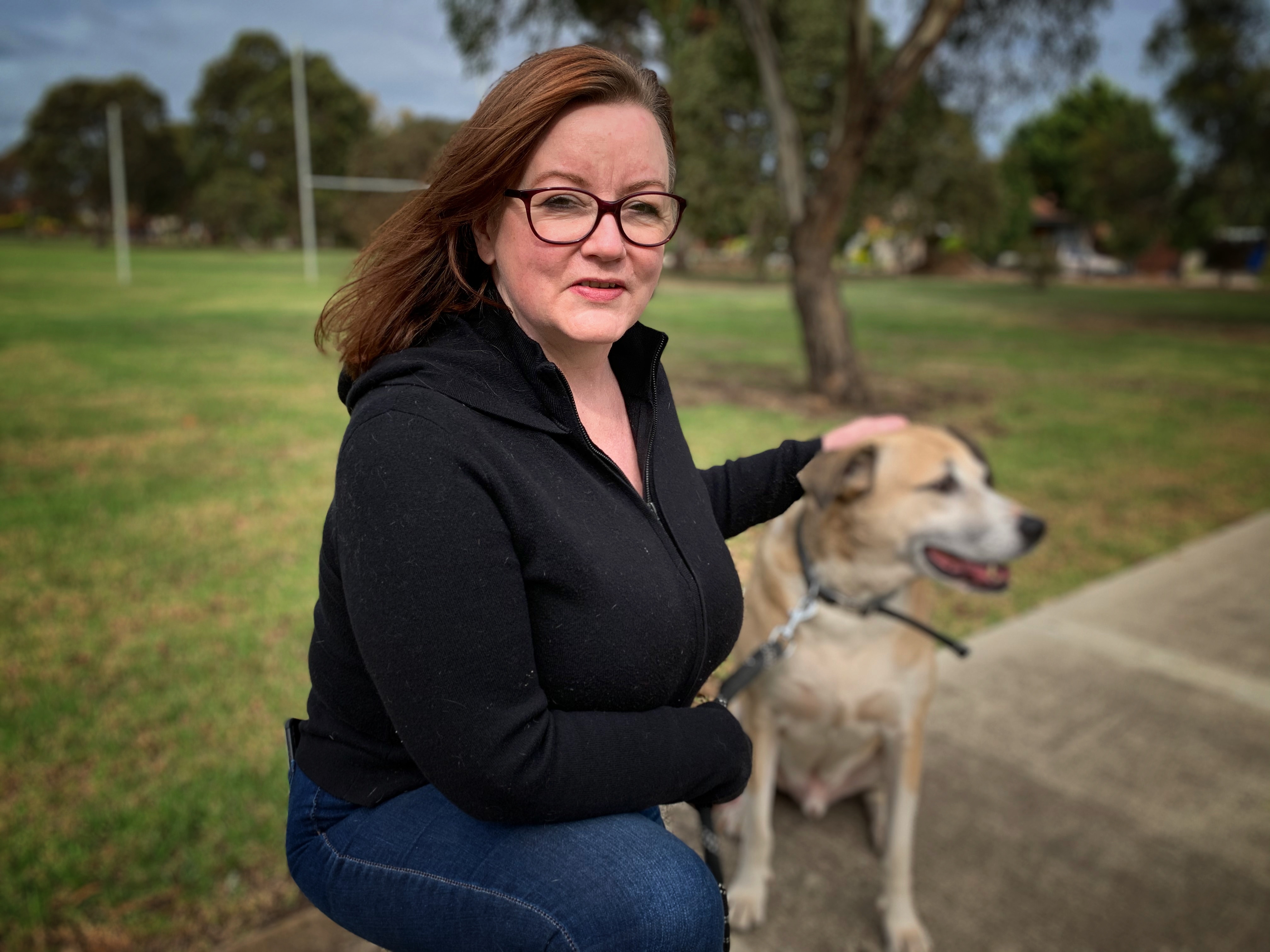 A woman and her dog in a park.