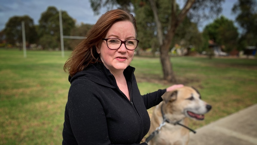 A woman and her dog in a park.