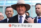 Wearing an akubra, Mr Joyce stands in front of colleagues.