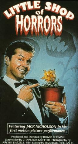 A man pointing to a plant with a venus fly trap as the shadow. 