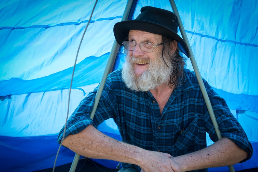 Man in hat under hand made blue hang glider