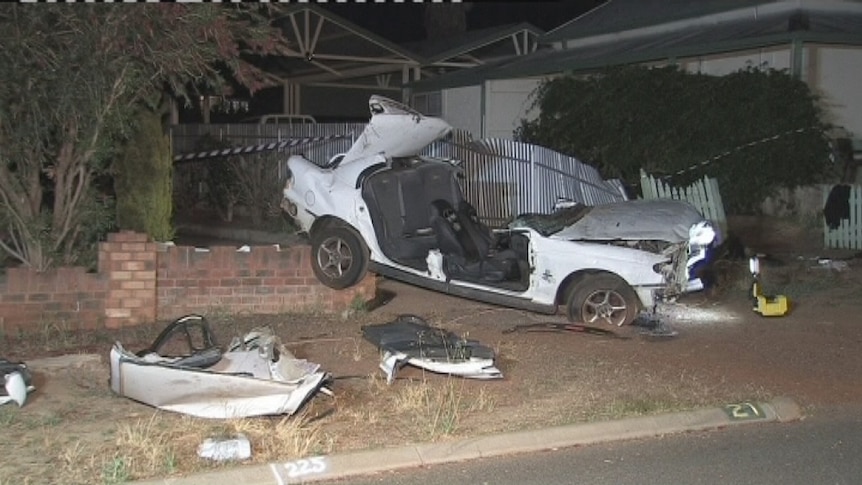 A car lies ripped apart after crashing in the front yard of a Northam property.