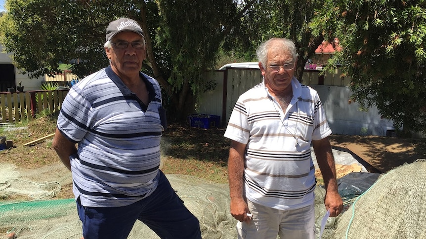 Andrew Nye and John Brierley, commercial cultural fisherman based in Moruya, check out their nets laid out on the ground.