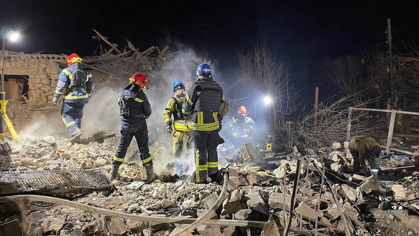 Rescuers work at the site of a Russian missile strike.