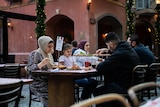 a family sitting at a table eating outdoors
