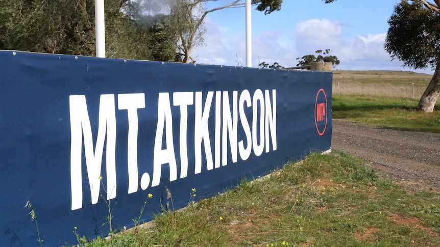 A "Mt Atkinson" sign sits in front of green paddocks on land that will become a new suburb in Melbourne's west.