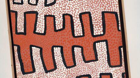 Ochre and cream dot with black out lines on oval shaped board from the early Papunya paintings of the 1970s