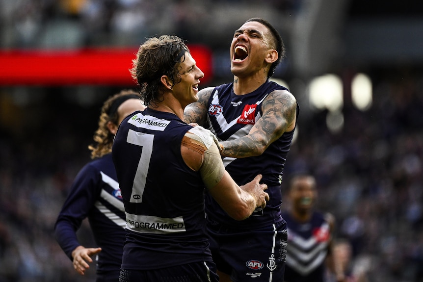 Michael Walters jumps into Nat Fyfe while screaming in delight