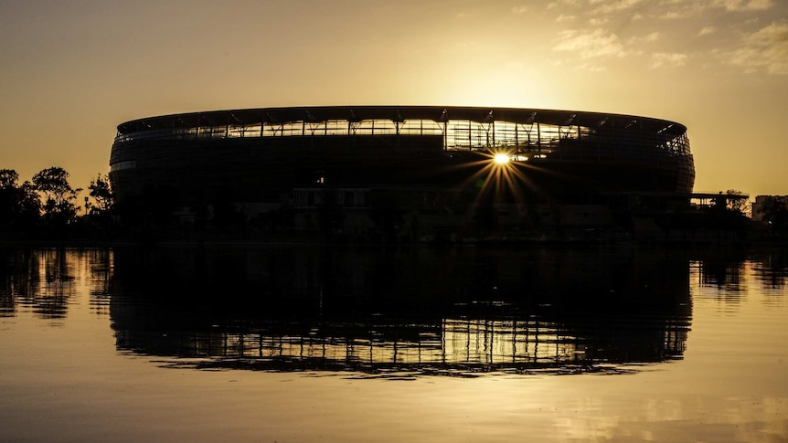 Perth Stadium in silhouette at sunrise