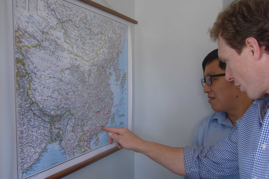 Two men look at a map of China