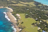 An aerial view of Lord Howe Island cliffs, beach and a few scattered houses
