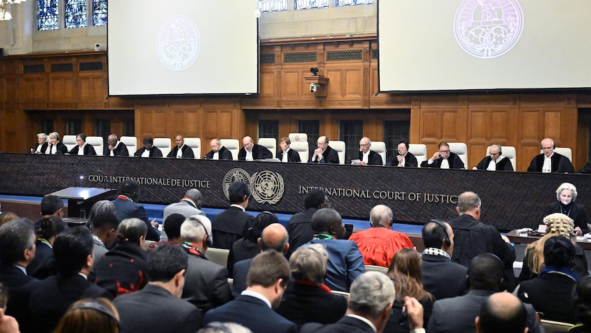 Seventeen male and female judges seated at the ICJ bench in front of lawyers and members of the public.