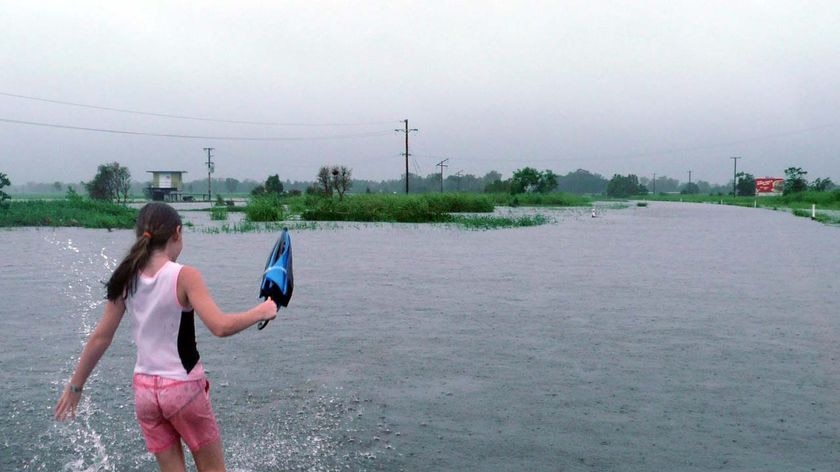Imogen Price walks through floodwaters south of Ingham.