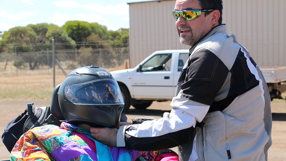 David Barker checks the strap on his daughter Shanniah's motorbike helmet as she sits in the bike's sidepod.