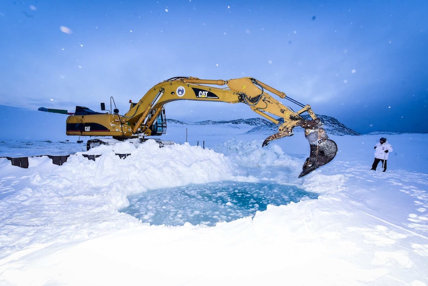 A machine digs out an icy pool in the middle of Antarctica