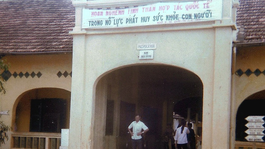 Entrance to a sandstone building with signage in Vietnamese