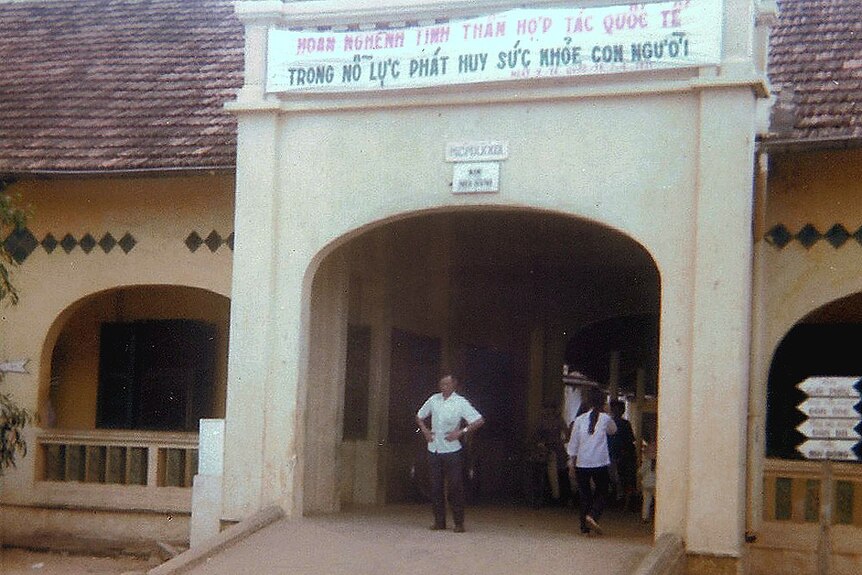 Entrance to a sandstone building with signage in Vietnamese