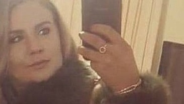 Gemma raises her smartphone to take a selfie in the mirror