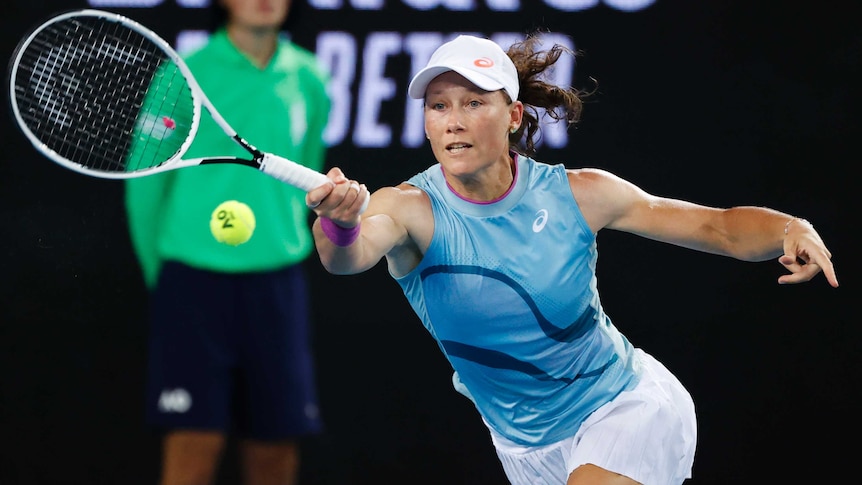 An Australian tennis player reaches to her right to hit a forehand during an Australian Open match.