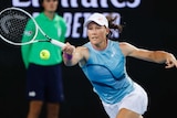 An Australian tennis player reaches to her right to hit a forehand during an Australian Open match.