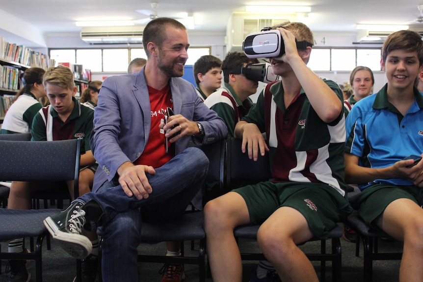 Griffith University researcher Dr Timo Dietrich tries out new technology on Year 10 students in Cairns.
