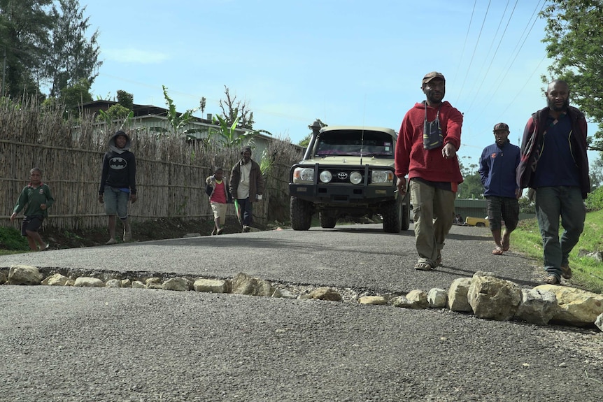 Locals fill a large crack in road with boulders in Mendi