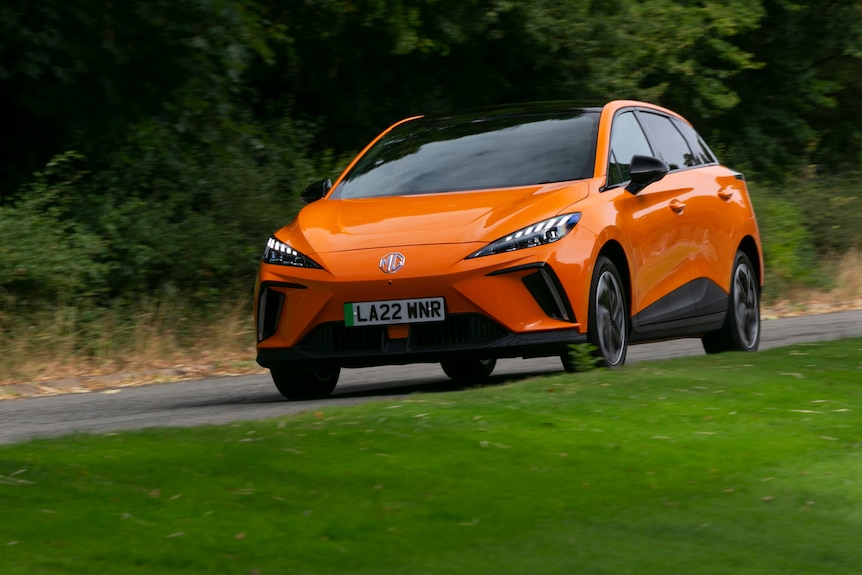 An orange EV from automaker MG on the road.